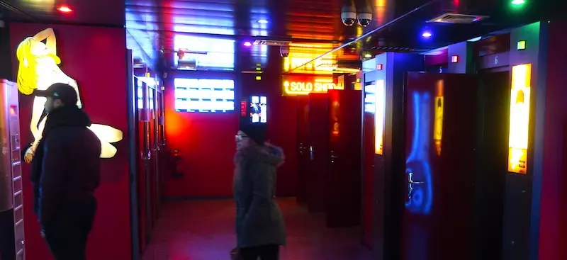 Visitors inside the neon-lit interior of the Amsterdam peep show Sex Palace