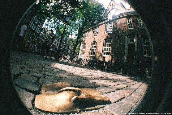 Street Art in Amsterdam. An hidden piece (hand on chest) in the Red Light District.