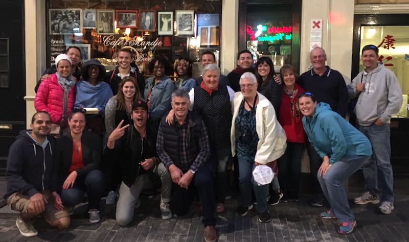 group of tourists who joined our Amsterdam Red Light District Walking Tour with our local guide Martijn and posing on the Zeedijk