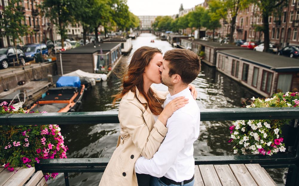 een man en vrouw zoenend tijdens een sexdate op een gracht in Nederland