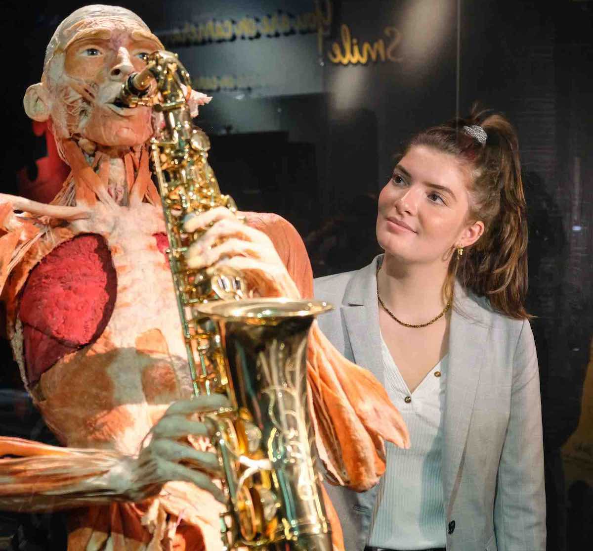 a brunette woman looking at one of the highlights inside Body Worlds in Amsterdam