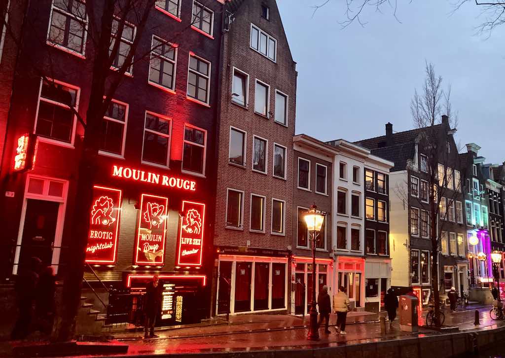 front view of Moulin Rouge in Amsterdam Red Light District with some people on the street