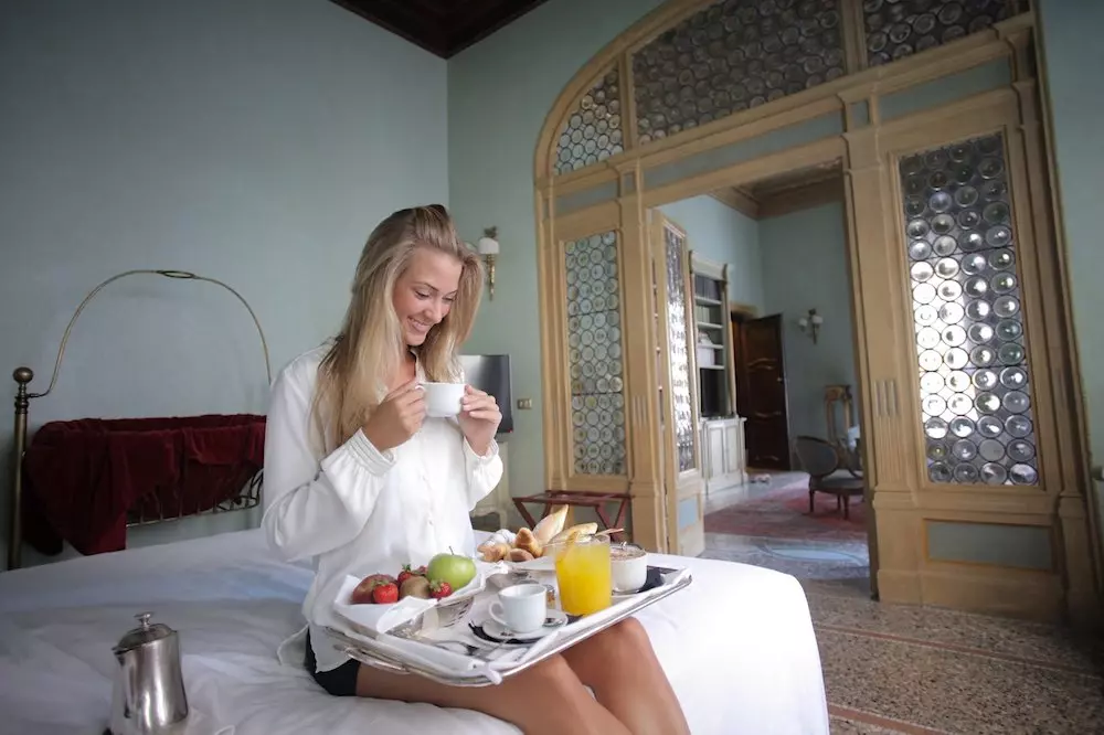 woman looking at her breakfast in a hotel room