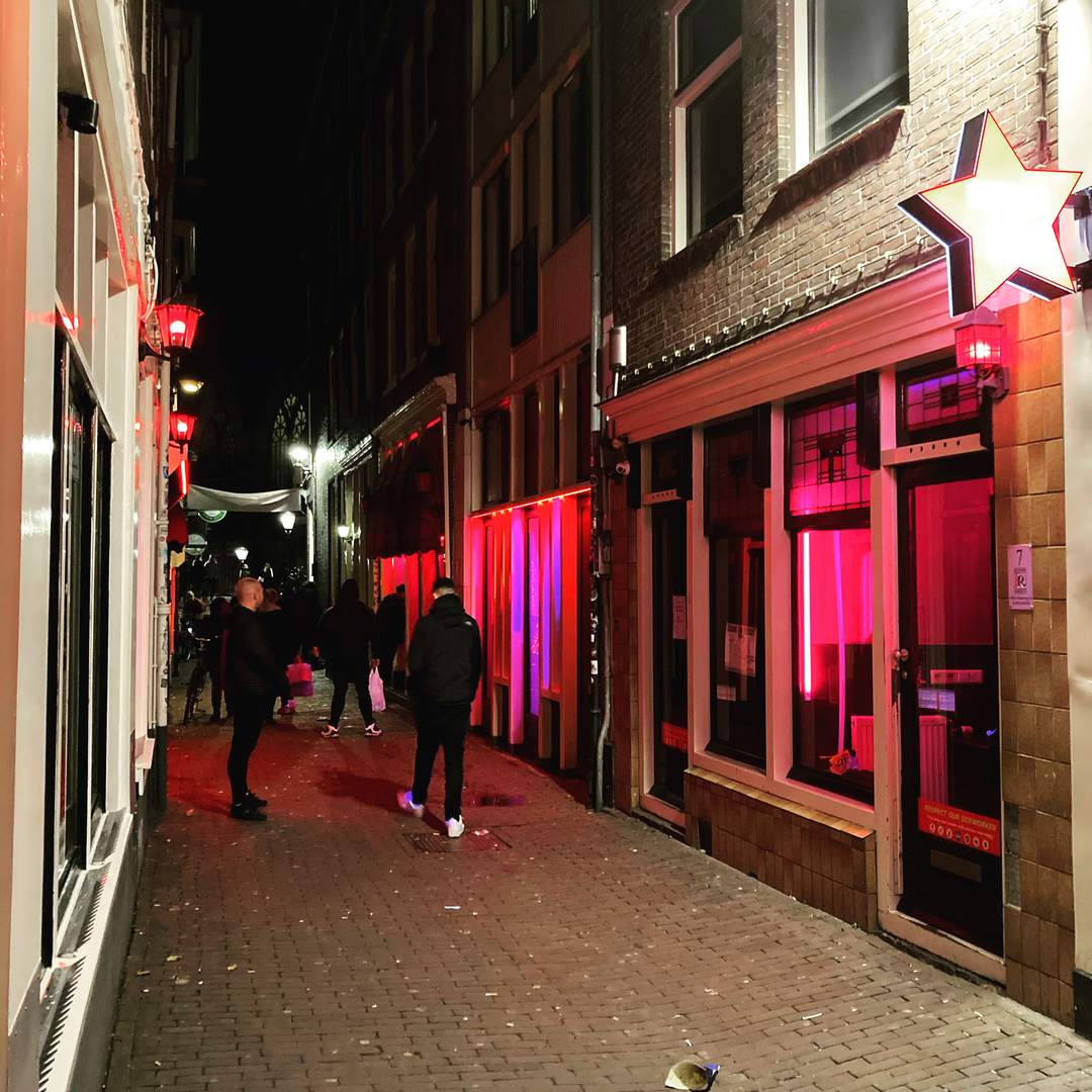 Red-lit window brothels along Oudekennissteeg in Amsterdam’s Red Light District at night