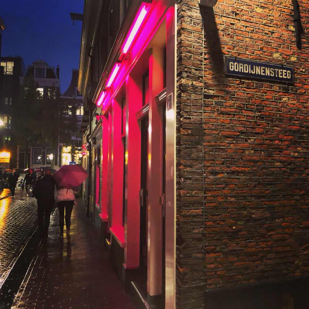 Gordijnensteeg street sign and lit window brothels at night in Amsterdam’s Blue Light District, De Wallen.